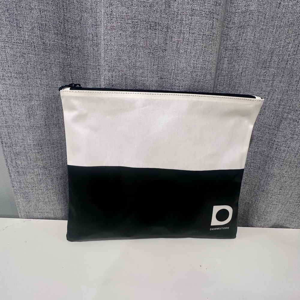 White and black dermstore cosmetic bag with zipper.
